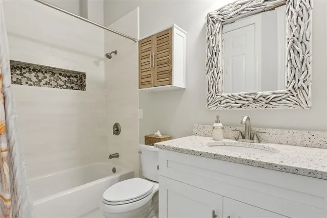a bathroom with a granite countertop sink a toilet and a bathtub