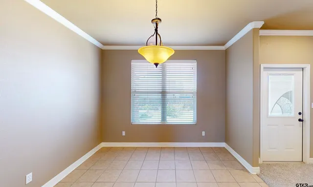 a view of an empty room with window and closet area
