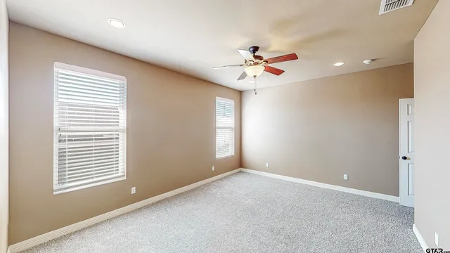 a view of room with a ceiling fan and a window