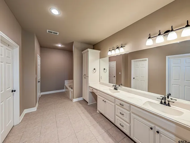 a spacious bathroom with a double vanity sink mirror and double