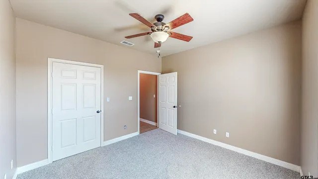 an empty room and chandelier fan