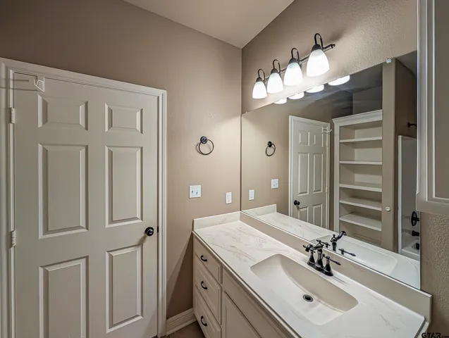 a bathroom with a sink vanity and a mirror