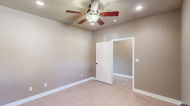 an empty room with closet and fan