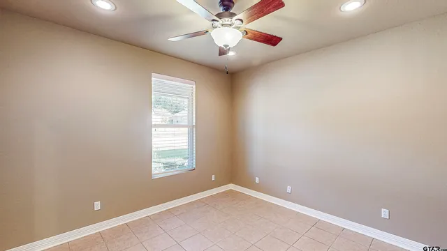 an empty room with windows and fan