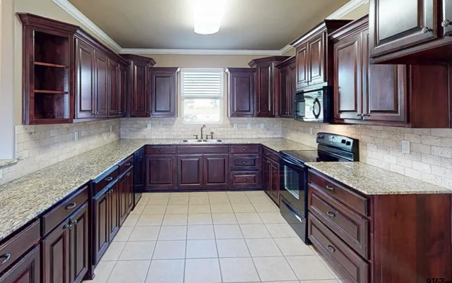 a kitchen with stainless steel appliances granite countertop a sink stove and cabinets