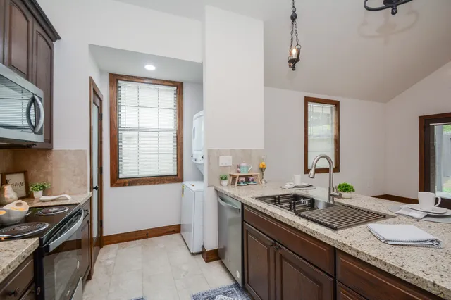 a kitchen with stainless steel appliances granite countertop a sink stove and refrigerator
