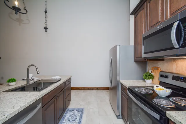 a kitchen with a sink and a stove with wooden floor