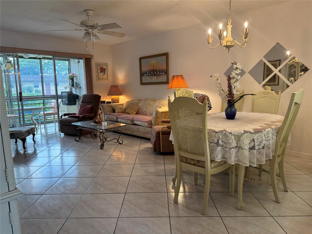 a living room with furniture a chandelier and a floor to ceiling window