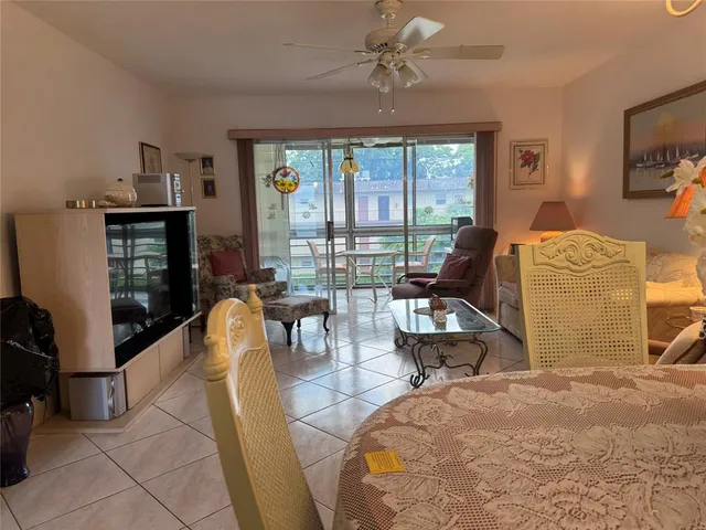 a living room with furniture a flat screen tv and a floor to ceiling window