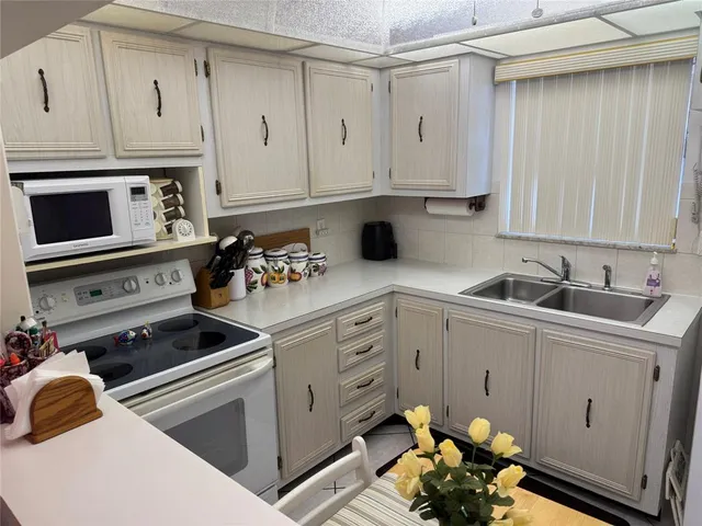 a kitchen with stainless steel appliances white cabinets and a stove top oven