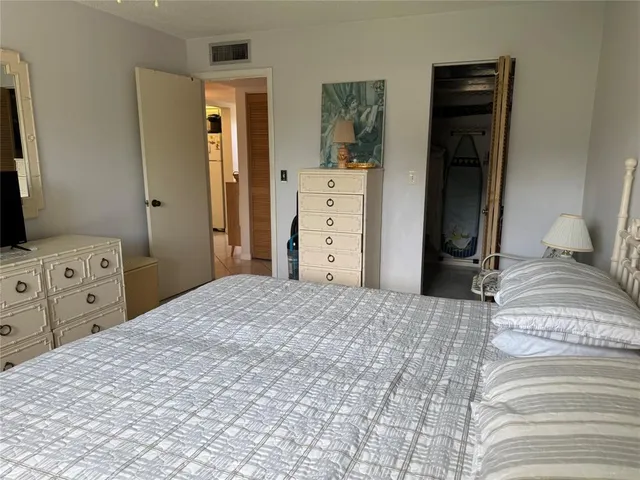 a bedroom with a bed and a tv on the dresser