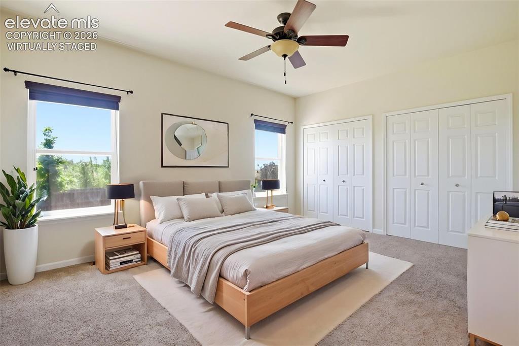 7806 Dutch Loop Colorado Springs, CO 80925 - Photo 13 of 41 a spacious bedroom with a bed a couch and a potted plant
