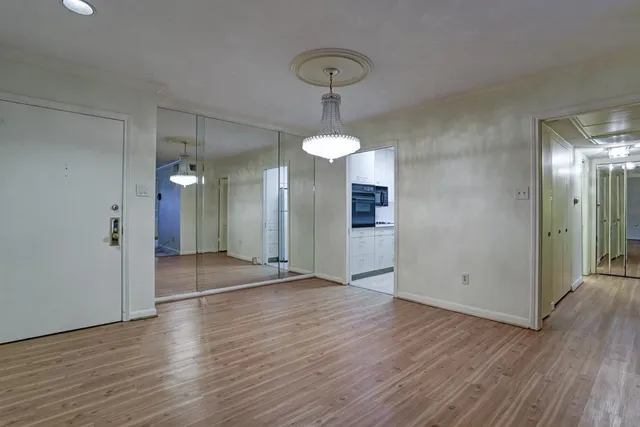 a view of a room with wooden floor and chandelier