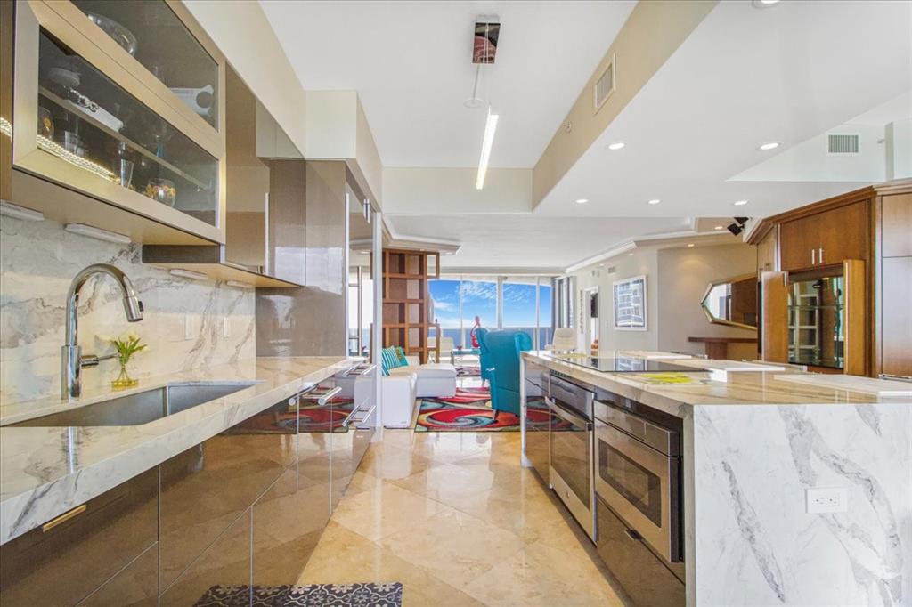 3100 North Ocean Boulevard, Unit 2103 Fort Lauderdale, FL 33308 - Photo 11 of 37 a kitchen with stainless steel appliances granite countertop a stove and a sink
