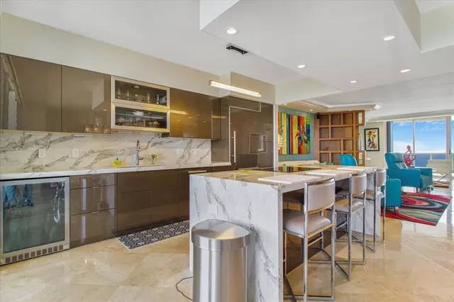 a kitchen with kitchen island granite countertop a sink and a refrigerator