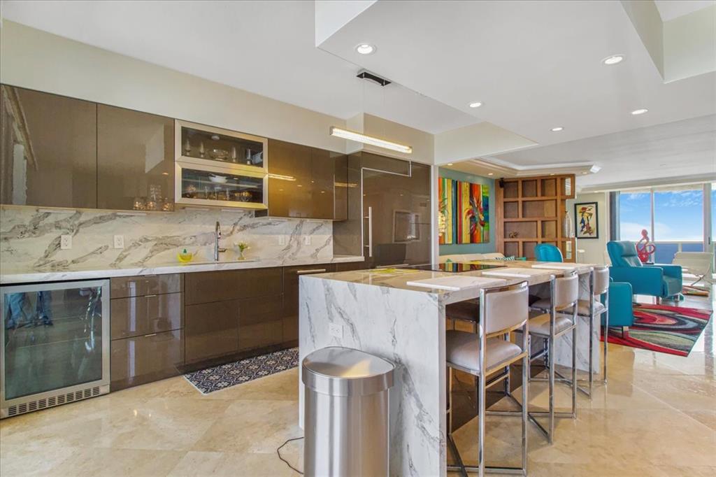 3100 North Ocean Boulevard, Unit 2103 Fort Lauderdale, FL 33308 - Photo 12 of 37 a kitchen with kitchen island granite countertop a sink and a refrigerator