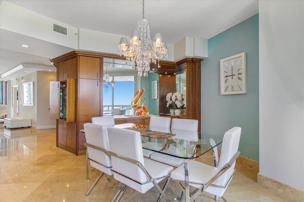 3100 North Ocean Boulevard, Unit 2103 Fort Lauderdale, FL 33308 - Photo 17 of 37 a view of a dining room with furniture and chandelier