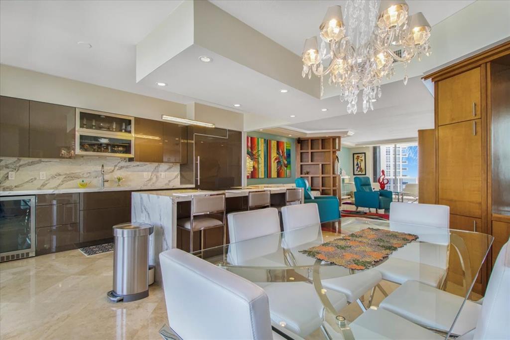 3100 North Ocean Boulevard, Unit 2103 Fort Lauderdale, FL 33308 - Photo 18 of 37 a living room with fireplace furniture and a chandelier