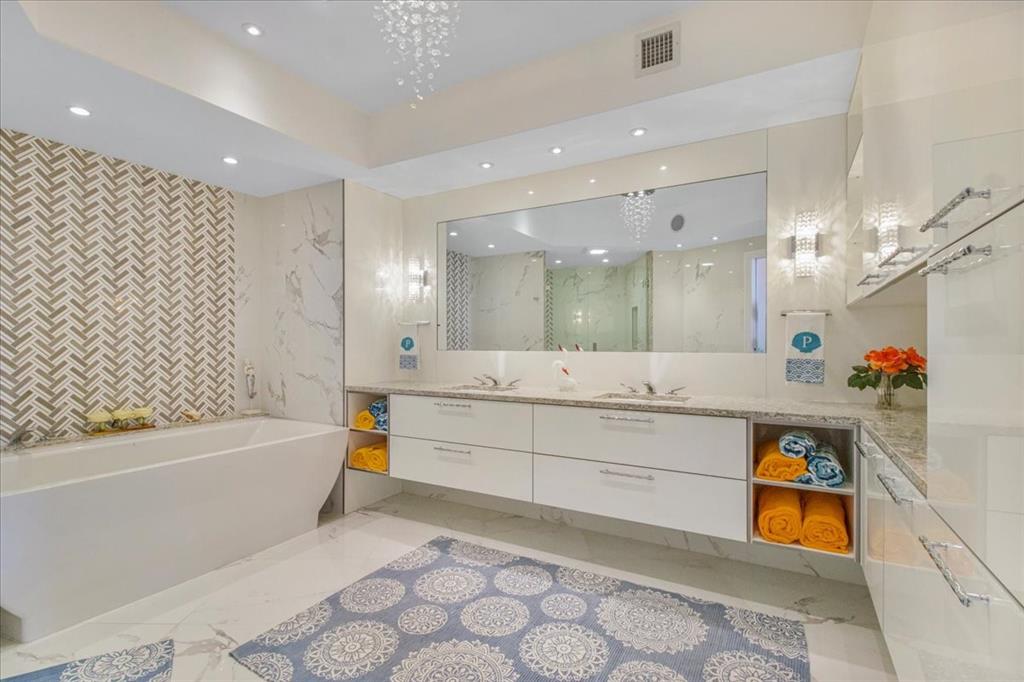 3100 North Ocean Boulevard, Unit 2103 Fort Lauderdale, FL 33308 - Photo 26 of 37 a bathroom with a bathtub a sink and a large mirror