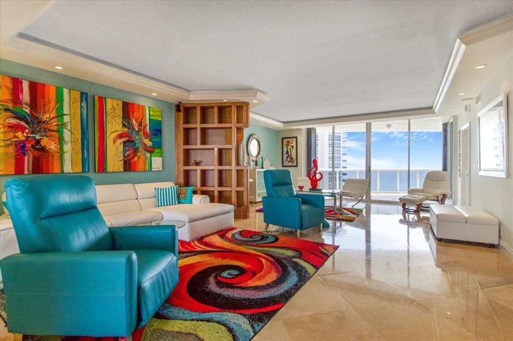 3100 North Ocean Boulevard, Unit 2103 Fort Lauderdale, FL 33308 - Photo 7 of 37 a living room filled with furniture and a book shelf