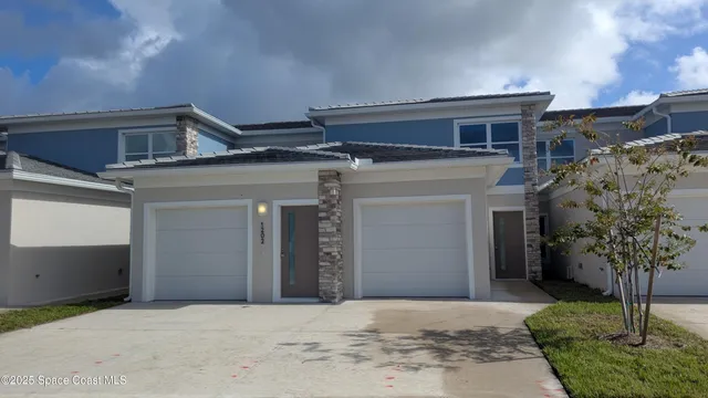 a view of house with outdoor space and trees in the background