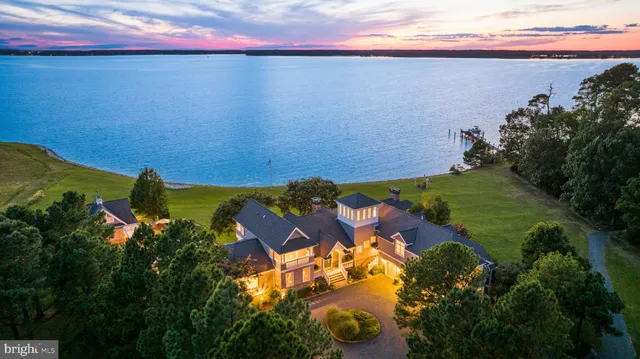 an aerial view of residential houses with outdoor space and trees all around