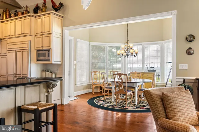 a bedroom with a bed a dresser and a chandelier