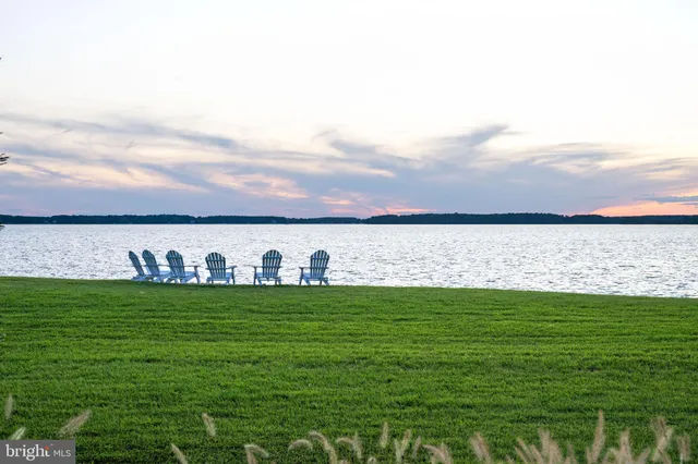 a living room with furniture and two large window