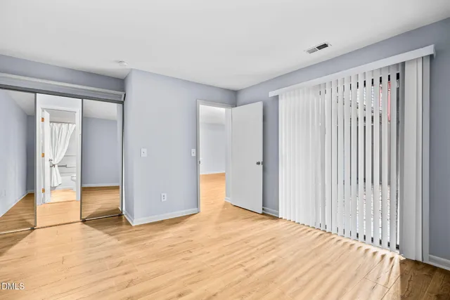 a view of empty room with wooden floor