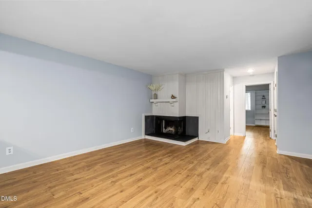 a view of empty room with wooden floor