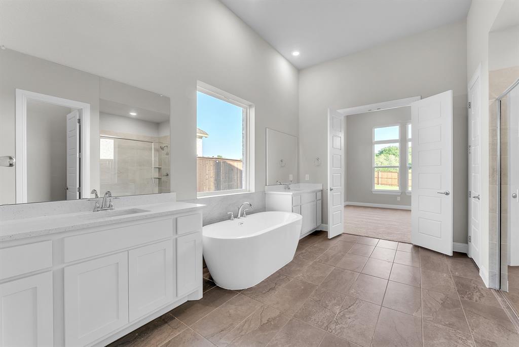 1215 Olive Drive Mansfield, TX 76063 - Photo 16 of 28 a spacious bathroom with a double vanity sink a mirror and a bathtub