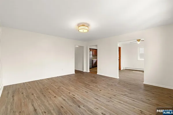 a view of an empty room with wooden floor