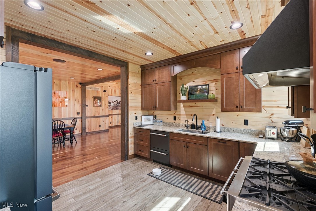 290 Townline Road Aurora, OH 44202 - Photo 19 of 50 Kitchen featuring freestanding refrigerator, range hood, stainless steel gas range oven, light wood-style floors, and recessed lighting