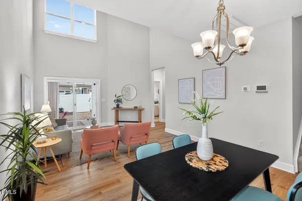 a living room with dining table a couches table and a potted plant