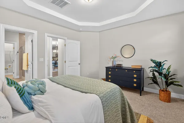 a bedroom with a large bed and a chandelier