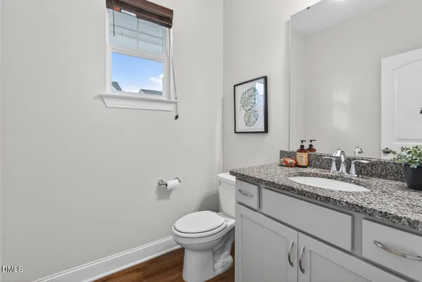 a bathroom with a granite countertop toilet sink and mirror