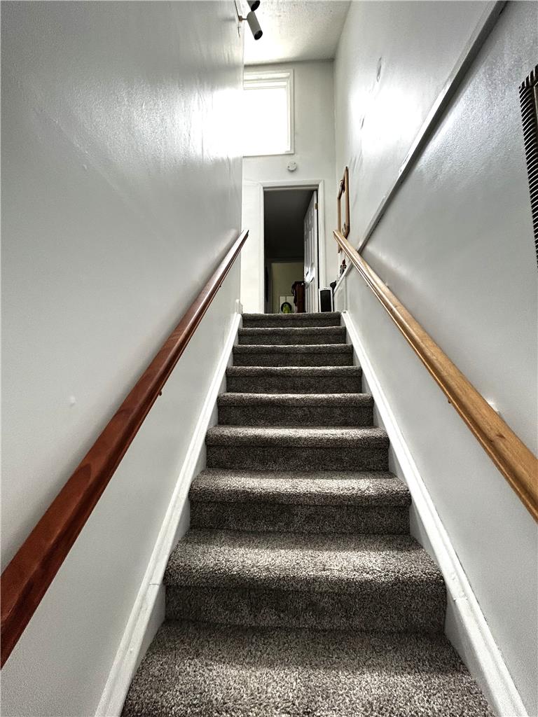 1214 Stanford Road Bethlehem, PA 18018 - Photo 36 of 58 Ascend carpeted stairs with sturdy handrails to an upper landing, bathed in light from a high window.