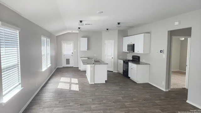 a view of a kitchen with furniture and wooden floor