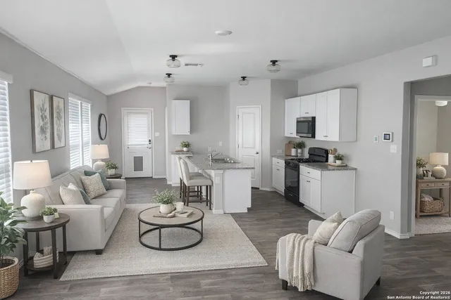 a living room with furniture and a view of kitchen