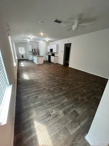 a view of empty room with wooden floor