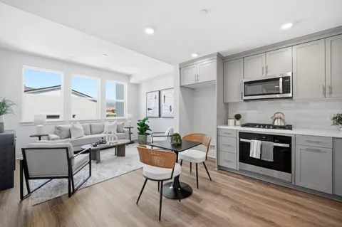 a kitchen with stainless steel appliances kitchen island granite countertop a stove a sink a microwave a dining table and chairs
