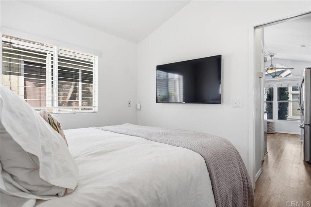 1624 North Coast Highway 101, Unit 6 Encinitas, CA 92024 - Photo 11 of 26 a bedroom with a bed and a flat tv screen on dresser