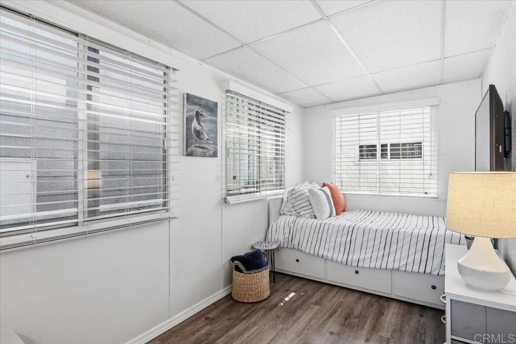 1624 North Coast Highway 101, Unit 6 Encinitas, CA 92024 - Photo 15 of 26 a bedroom with a bed and wooden floor