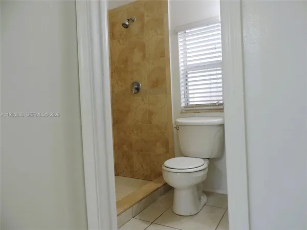 a white toilet sitting next to a bathroom sink and tub