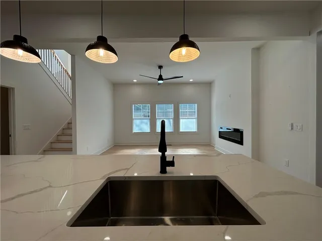 a living room with stainless steel appliances kitchen island furniture and a fireplace
