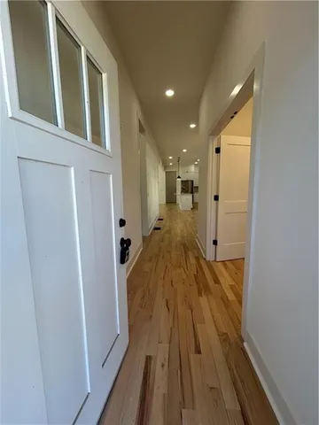 a view of a hallway with wooden floor and staircase