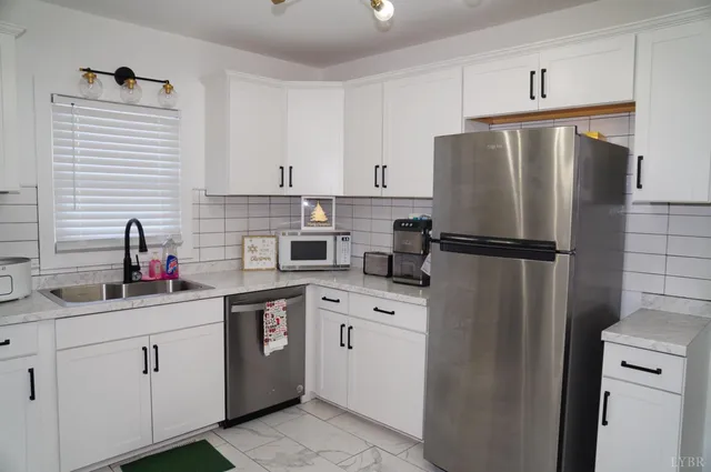 a kitchen with white cabinets and stainless steel appliances