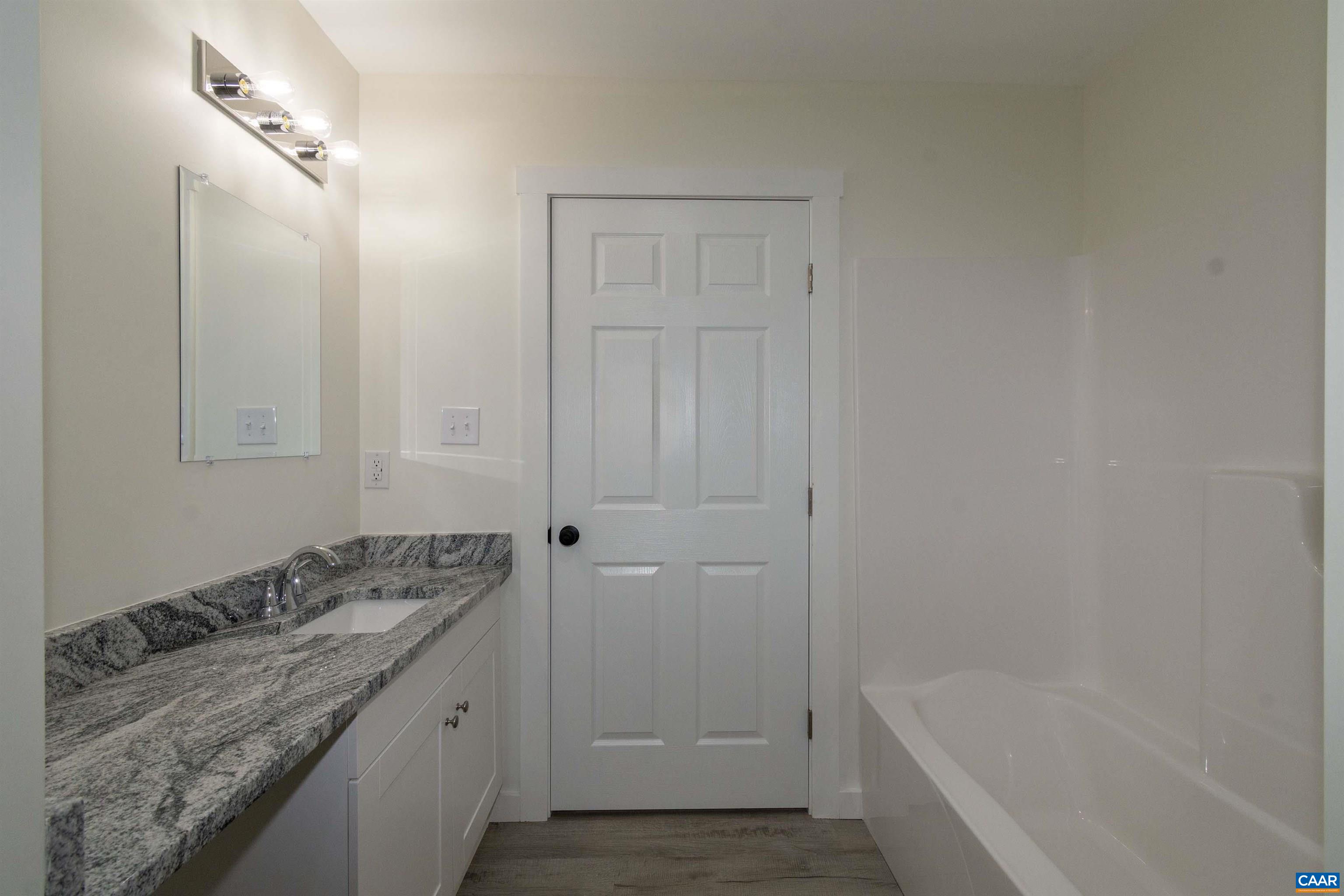 15301 Shirley Road Unionville, VA 22567 - Photo 17 of 27 a bathroom with a granite countertop sink and a bathtub