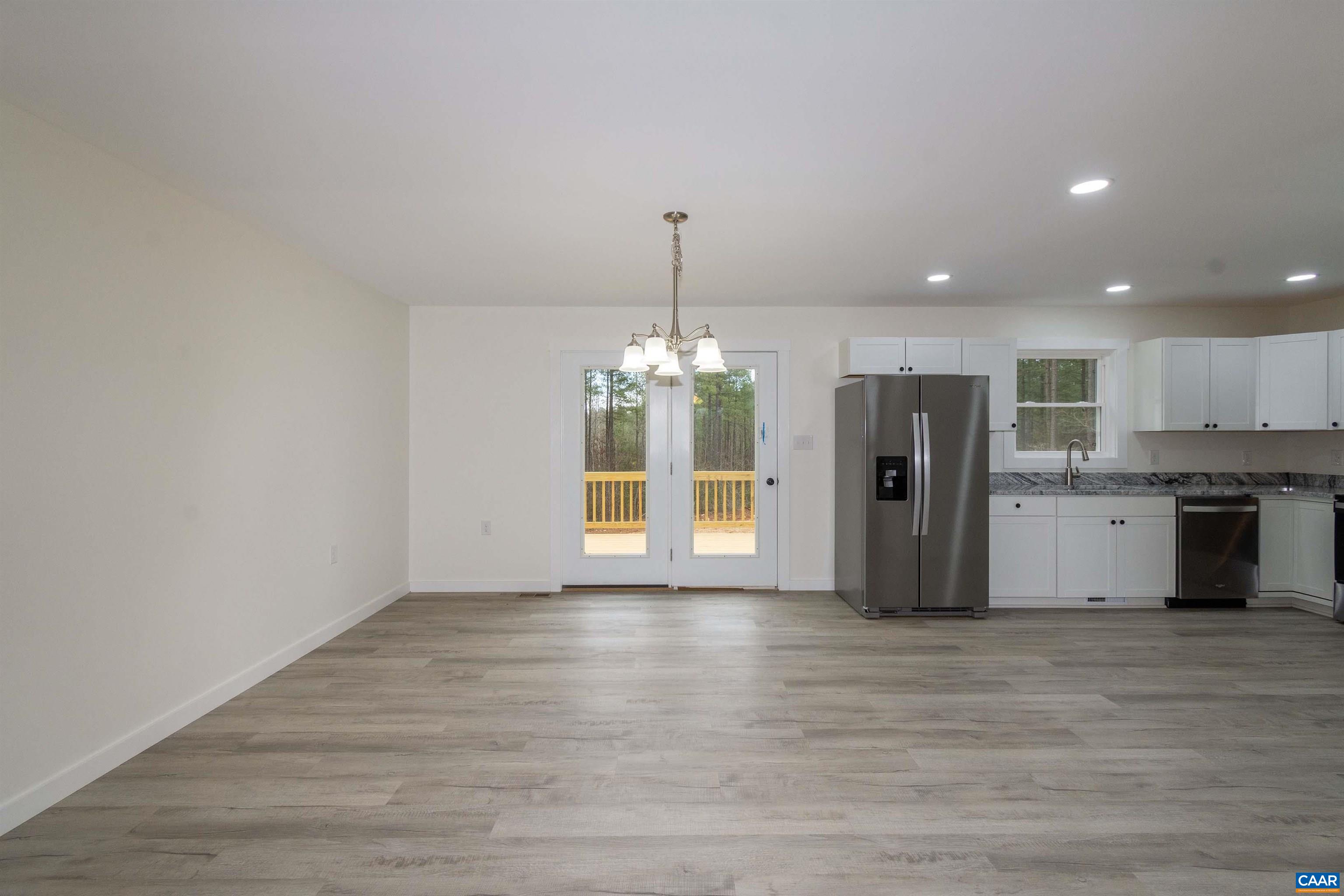 15301 Shirley Road Unionville, VA 22567 - Photo 5 of 27 a view of an empty room with wooden floor and a kitchen