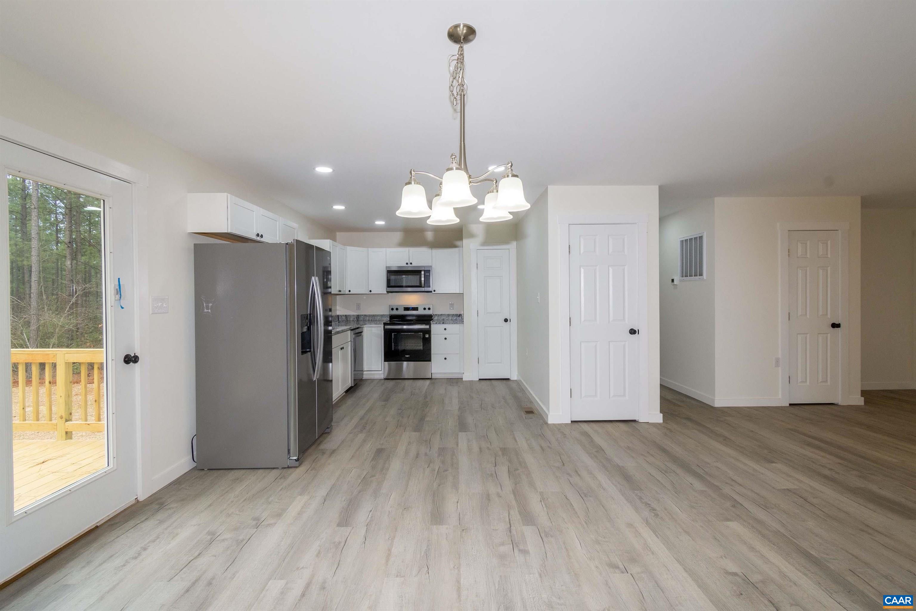 15301 Shirley Road Unionville, VA 22567 - Photo 6 of 27 a view of a kitchen with a refrigerator a stove top oven and wooden floor